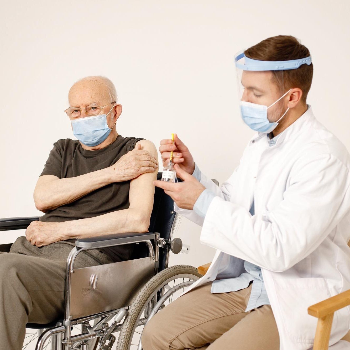 medico-masculino-anciano-silla-ruedas-aislado-fondo-blanco_1157-51896